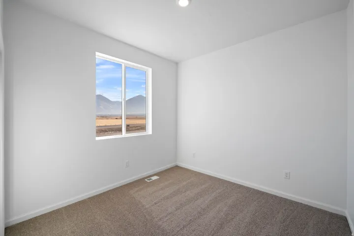Neutral tone interior with recessed lighting, wall-to-wall carpeting, and a window with mountain scenery
