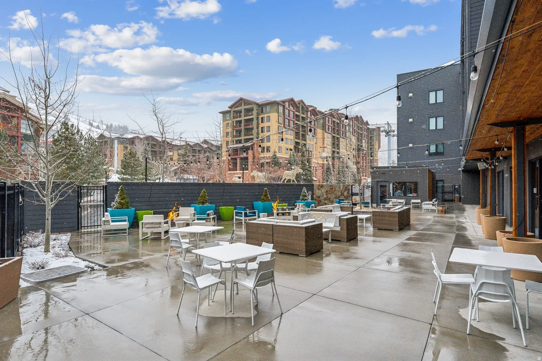 Expansive concrete patio with string lighting and a wood-paneled overhang