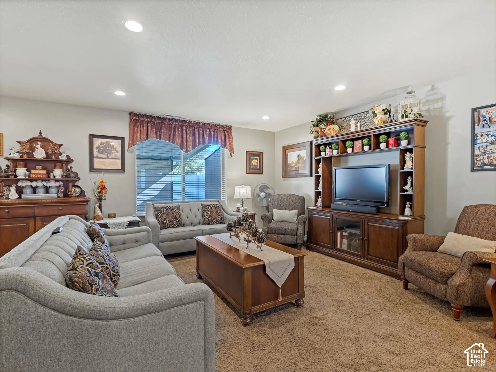 Recessed lighting, window with horizontal blinds, built-in media console, wood-finish flooring, and light-colored walls