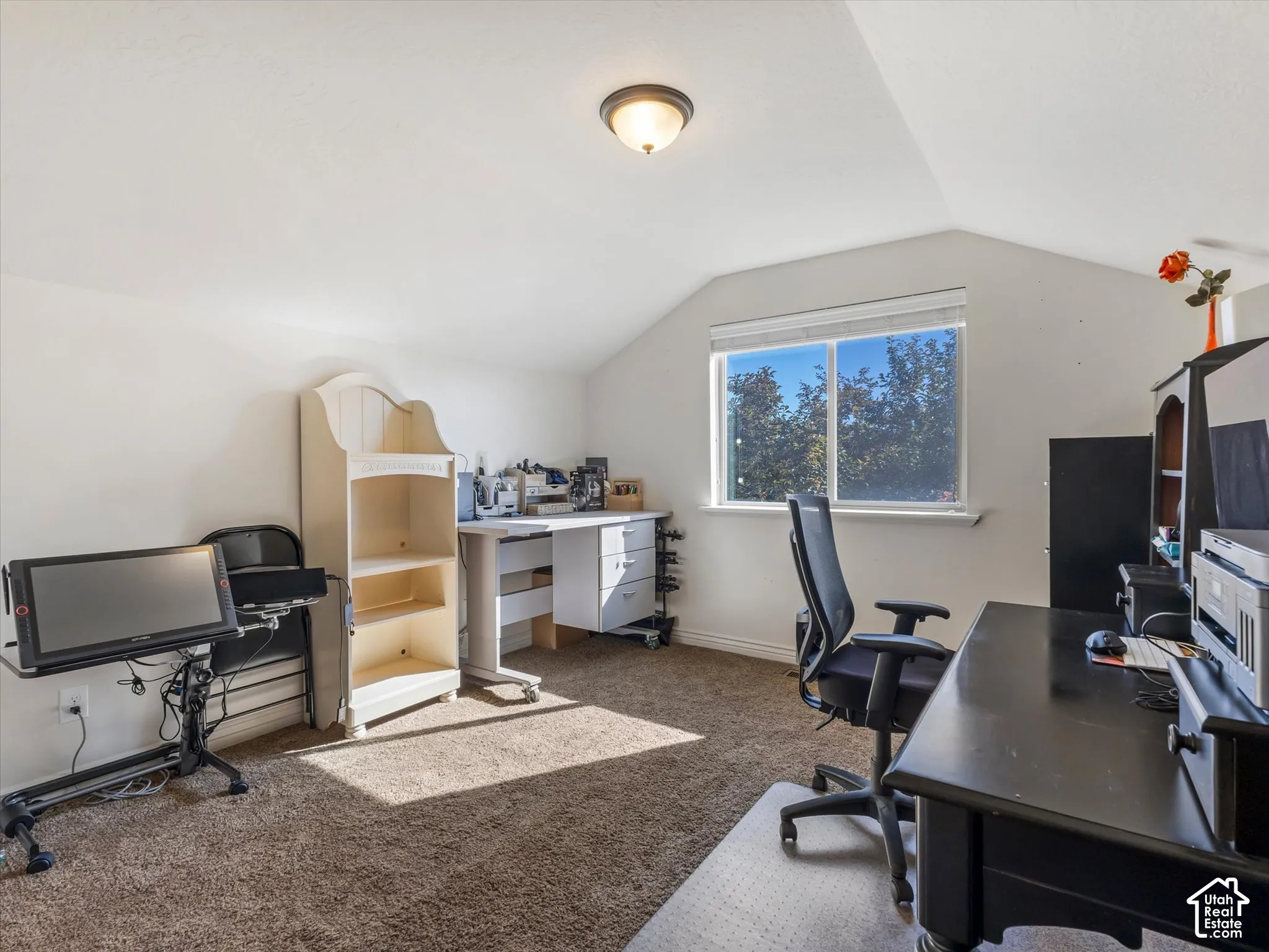 Carpeted room with a vaulted ceiling, a single window, and a flush mount ceiling light fixture