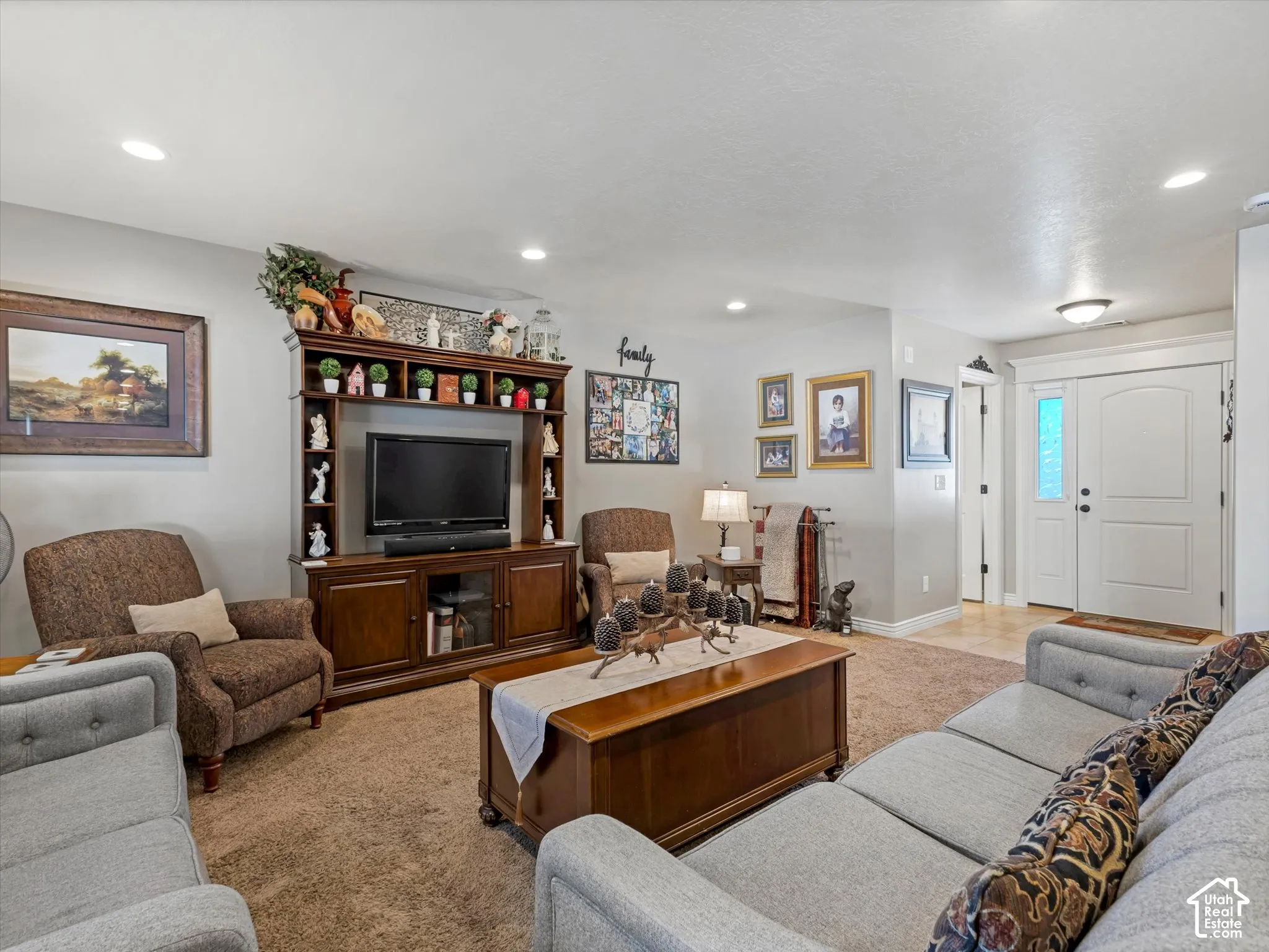 Recessed ceiling lighting, built-in entertainment center with shelving, light-toned wall paint, neutral-toned carpet, and a double entry door with frosted glass inserts
