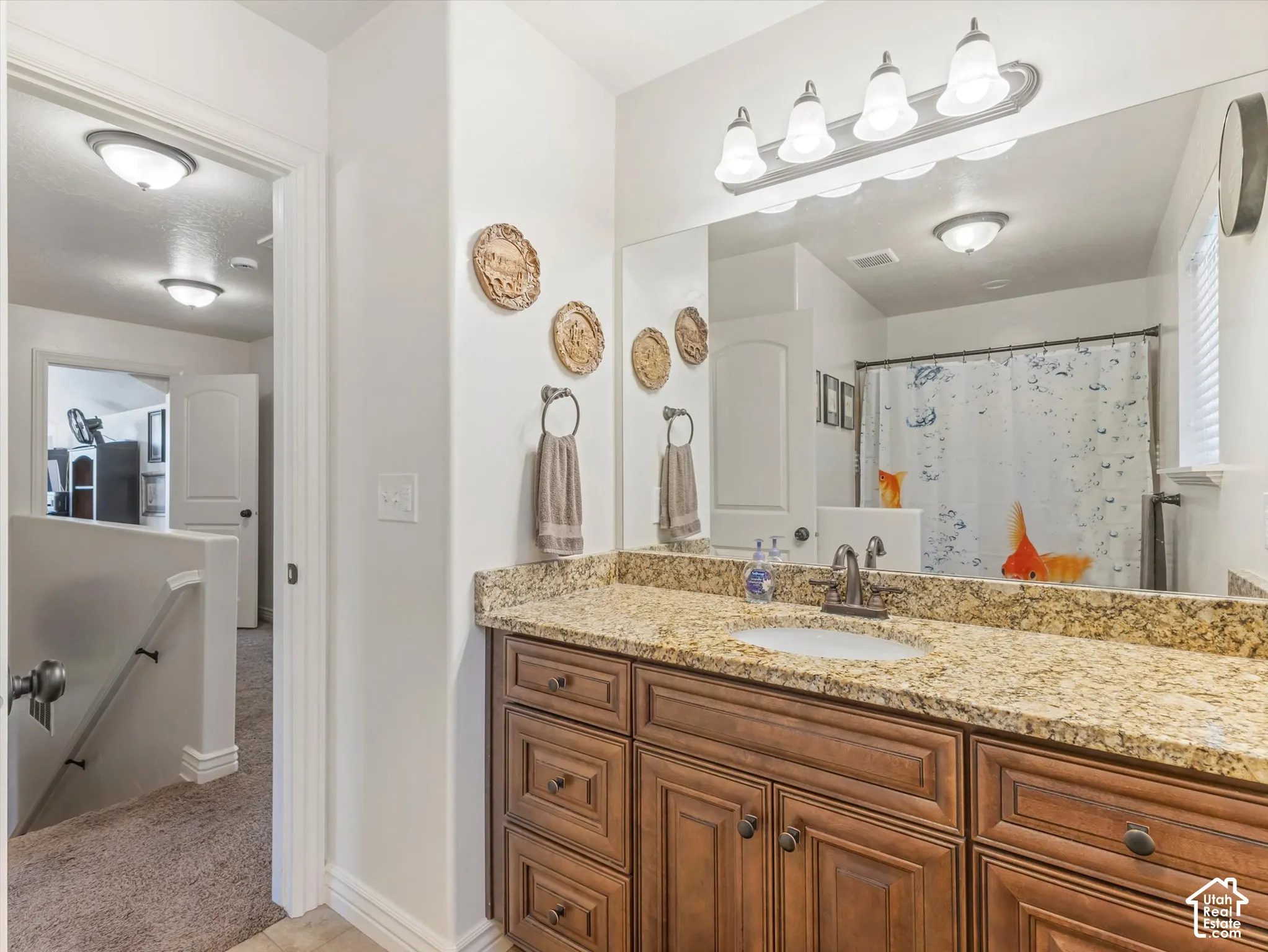 Bathroom featuring a vanity with a granite countertop, undermount sink, and wood-finish cabinetry