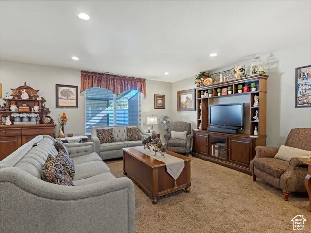 Recessed lighting, window with horizontal blinds, built-in media console, wood-finish flooring, and light-colored walls