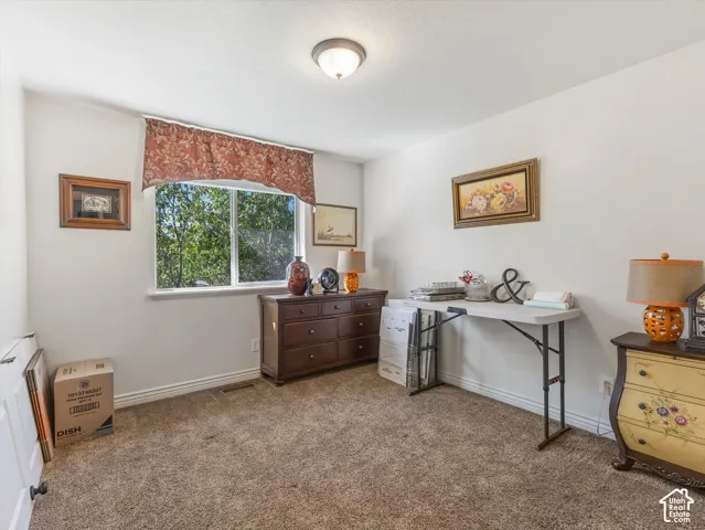Carpeted flooring, white walls, and a window with a valance