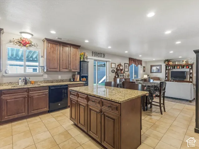 Kitchen featuring wood cabinetry, granite countertops, tile flooring, and recessed lighting