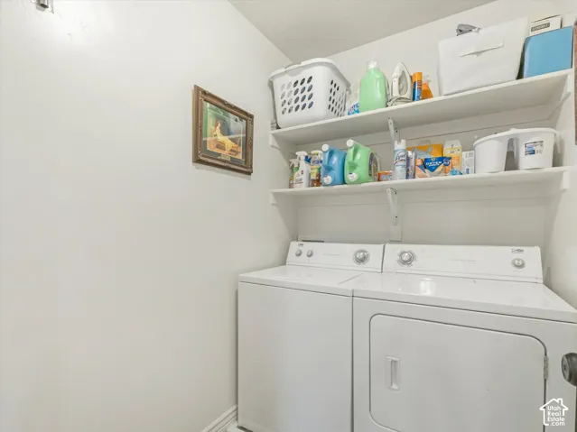 White washer and dryer units with upper wall-mounted shelving