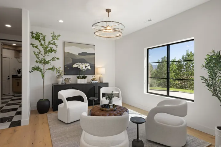 Large window with black grid framing, wood-finish flooring, recessed lighting, and a contemporary chandelier