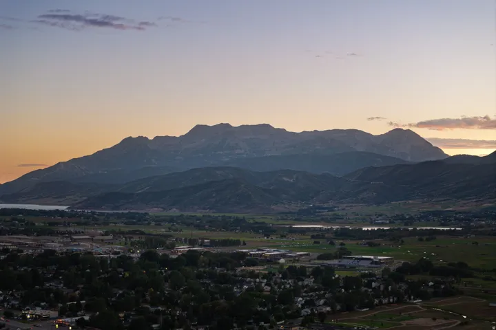 Expansive mountain range backdrop, large body of water, and residential areas