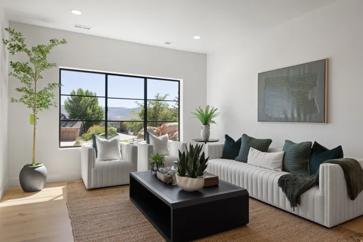 Large multi-pane window, light wood-finish flooring, recessed lighting, and white wall finishes