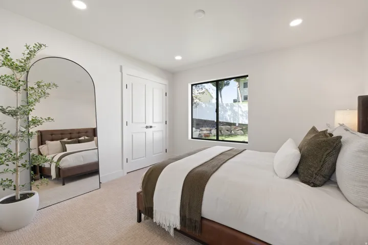 Recessed lighting, wood-finish flooring, and white paneled closet doors