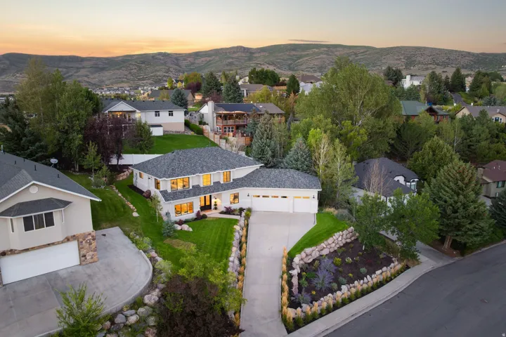 Contemporary exterior with a multi-car garage, manicured lawn, and established landscaping