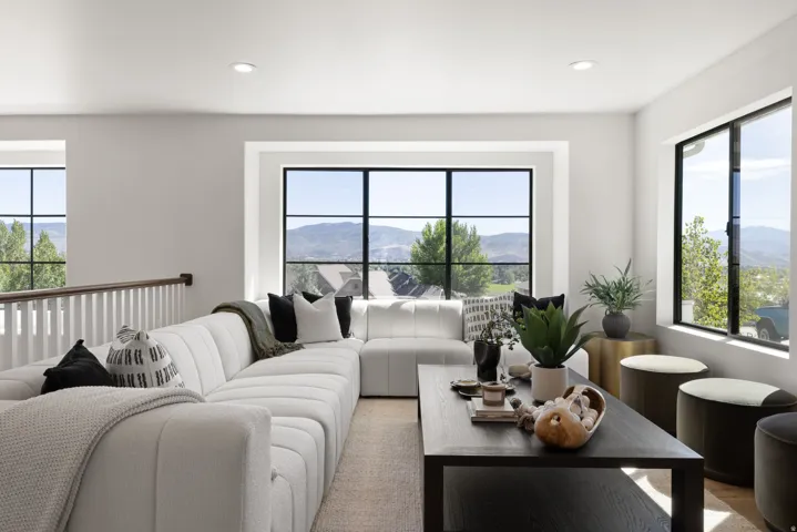 Recessed lighting, black-framed windows, and a wood-finish railing