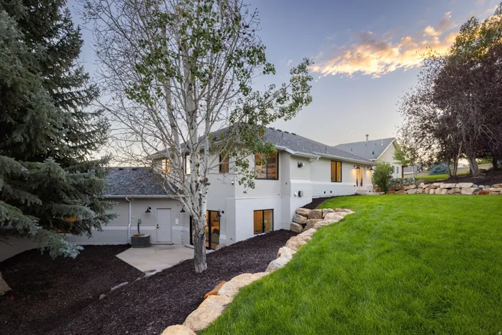 Expansive rear exterior with a pitched roof, multiple windows, and a concrete patio