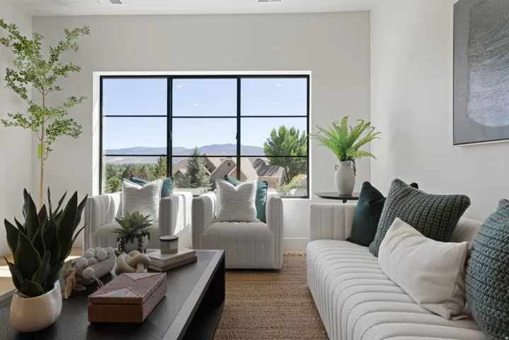 Expansive window with black framing, wood-finish flooring, white walls, and recessed lighting