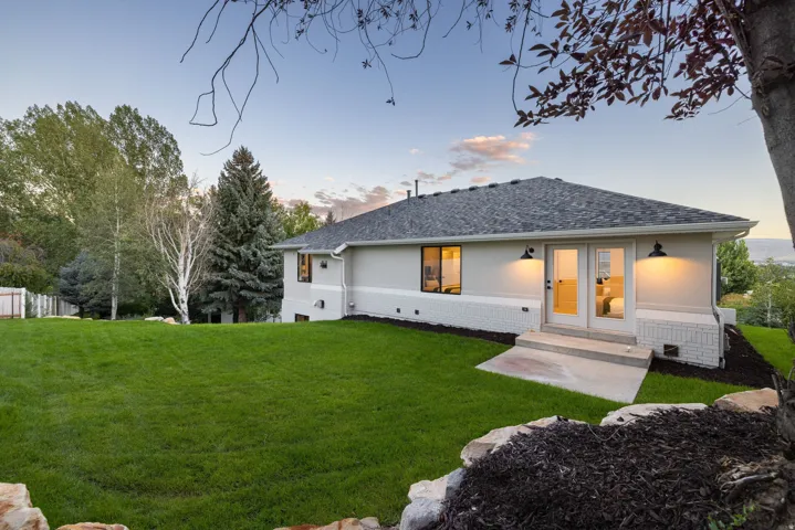 Expansive green lawn with mature trees and a fenced boundary