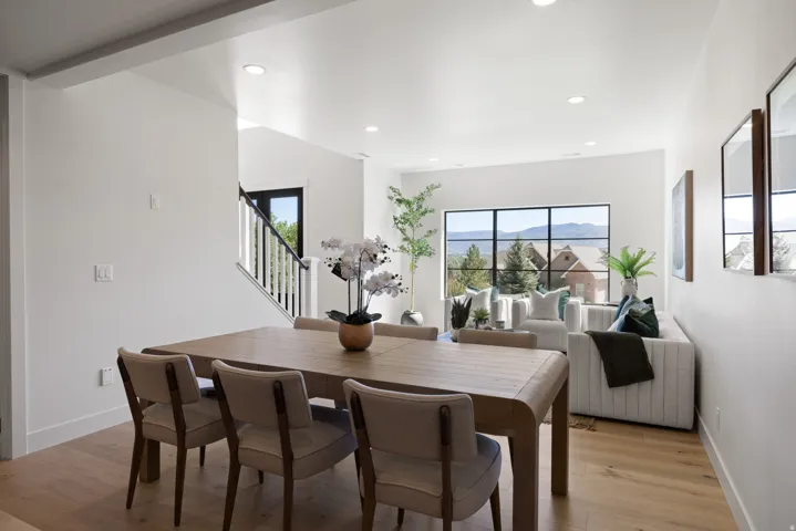 Spacious interior featuring light wood-finish flooring, recessed lighting, and a large multi-pane window with mountain scenery