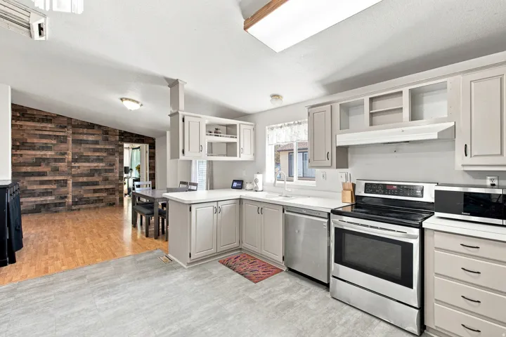 Kitchen featuring light-toned cabinetry, stainless steel appliances, and a white countertop