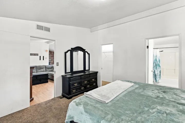 Wall-to-wall carpeting with an open doorway, a separate closet entry, and a full bathroom with a tub/shower combination