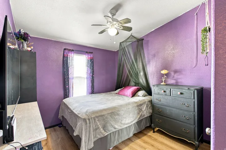 Window with drapes, wood-finish flooring, ceiling fan, and built-in wall texture