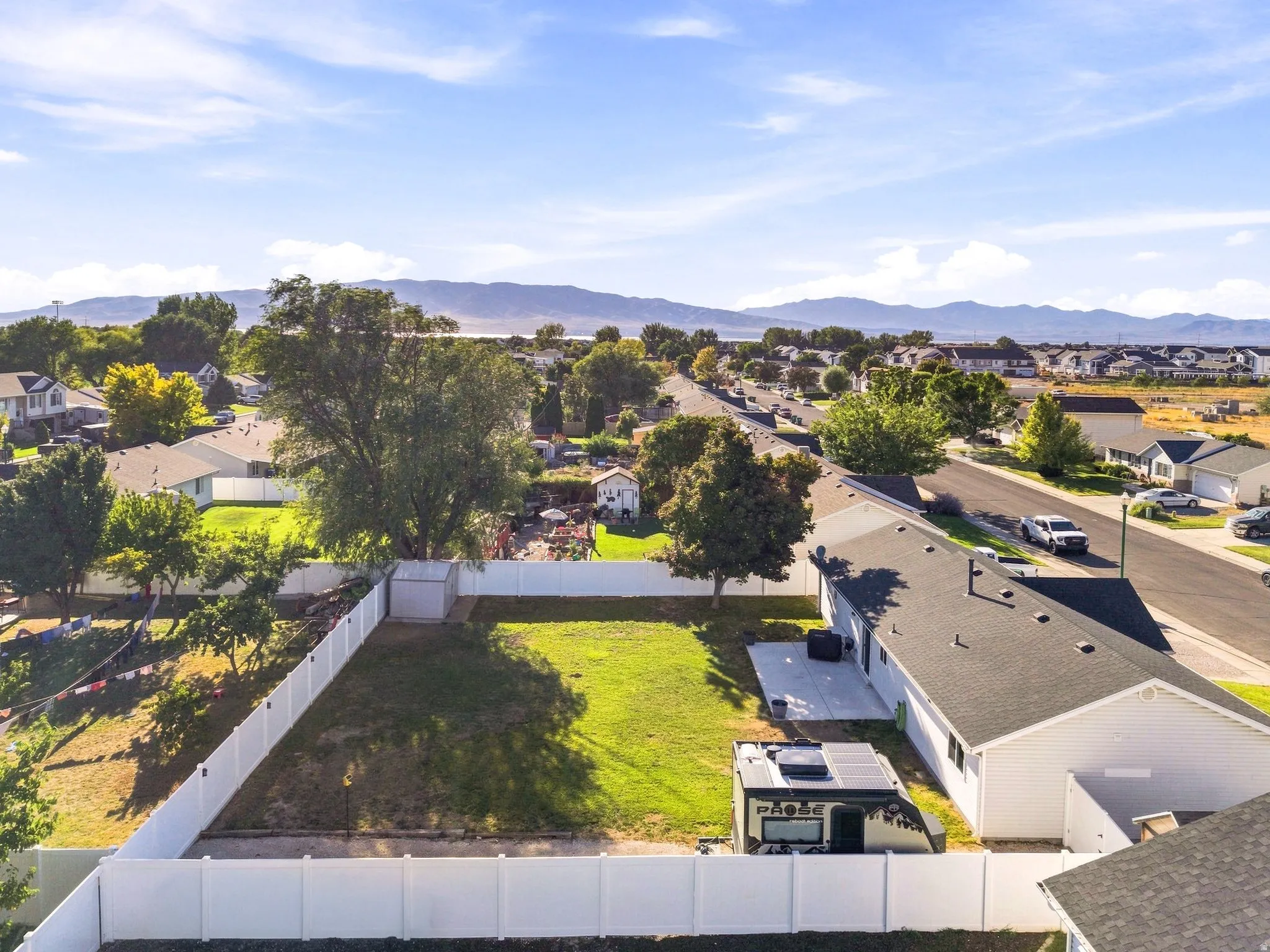 Expansive rear yard featuring a manicured lawn, full privacy fencing, and a concrete patio