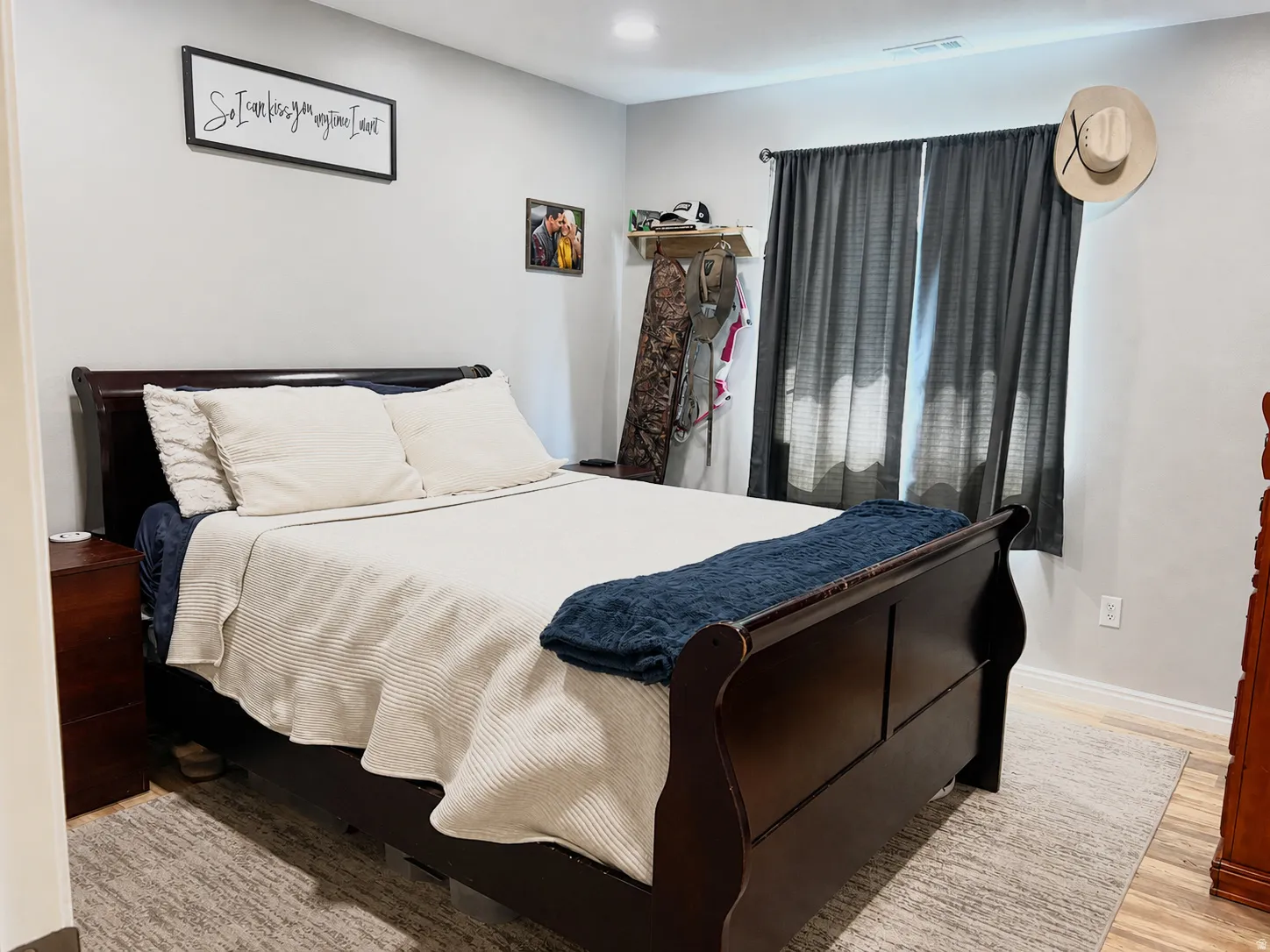 Recessed lighting, wood-finish flooring, and a window with dark drapery