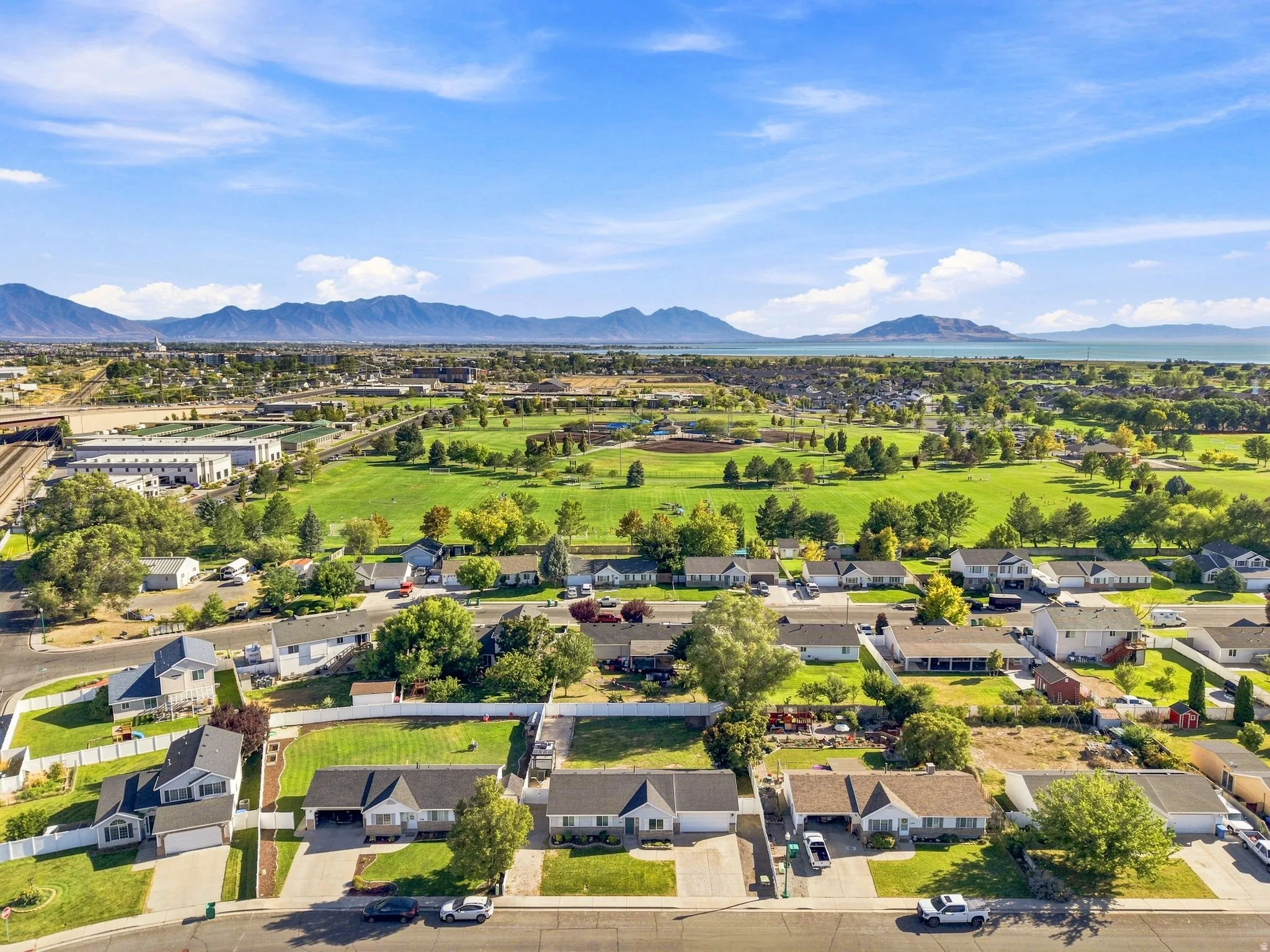 Expansive neighborhood featuring mature landscaping, a large green space, and distant mountain and water features