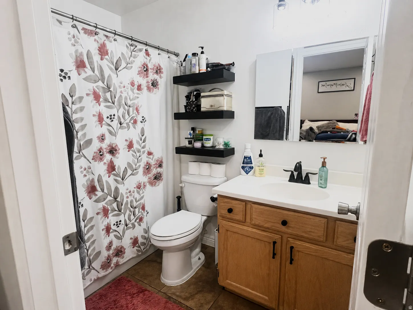 Vanity with wood-finish cabinetry, white countertop, and integrated sink
