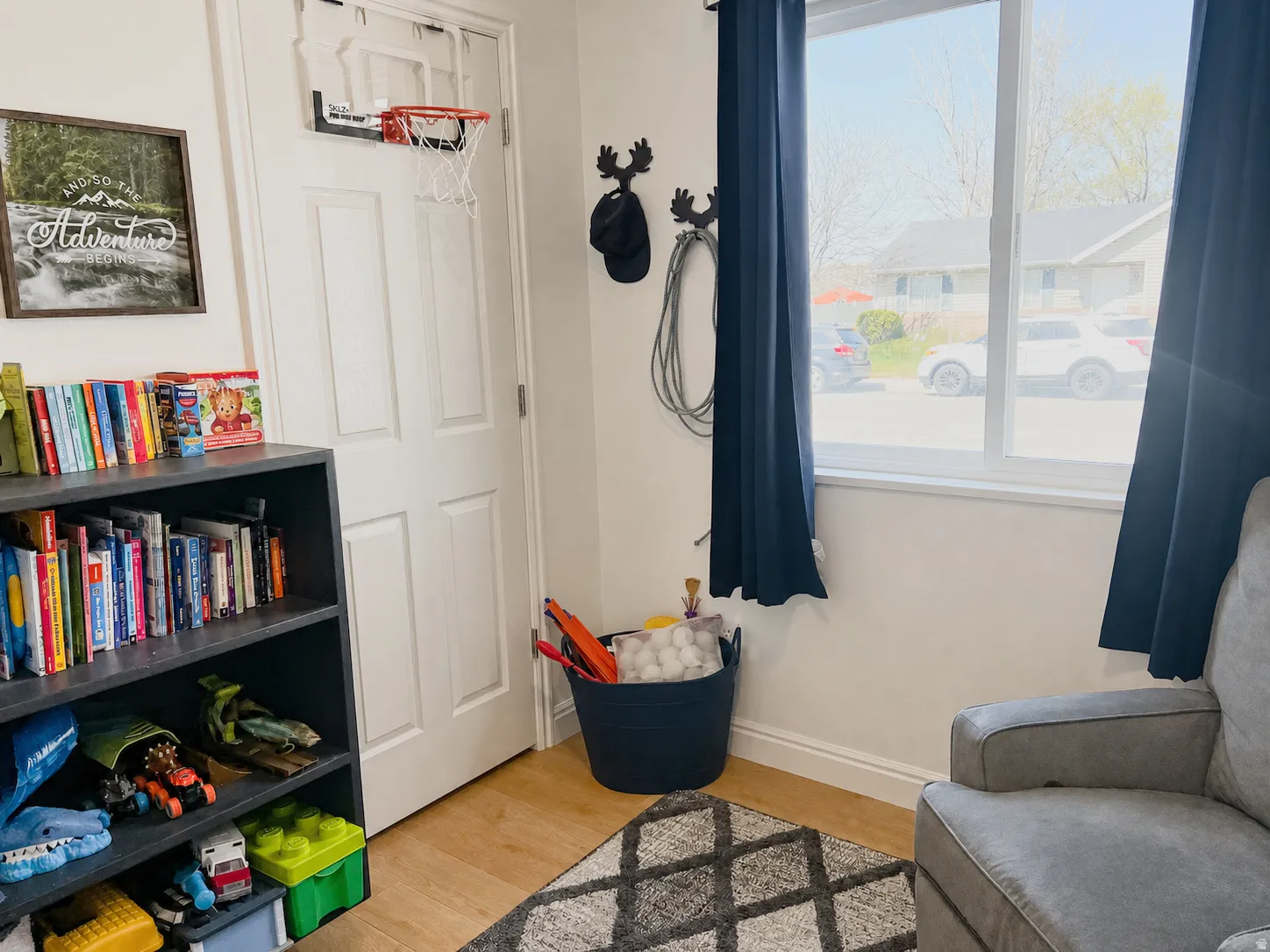 Recessed window with white trim, light-toned wood-finish flooring, and a built-in shelving unit