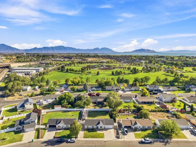 Expansive neighborhood featuring mature landscaping, a large green space, and distant mountain and water features