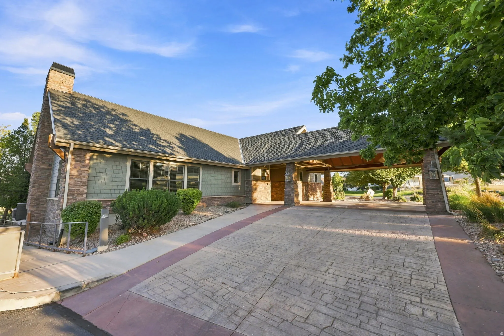 Stone and shingle exterior with a covered entryway and chimney