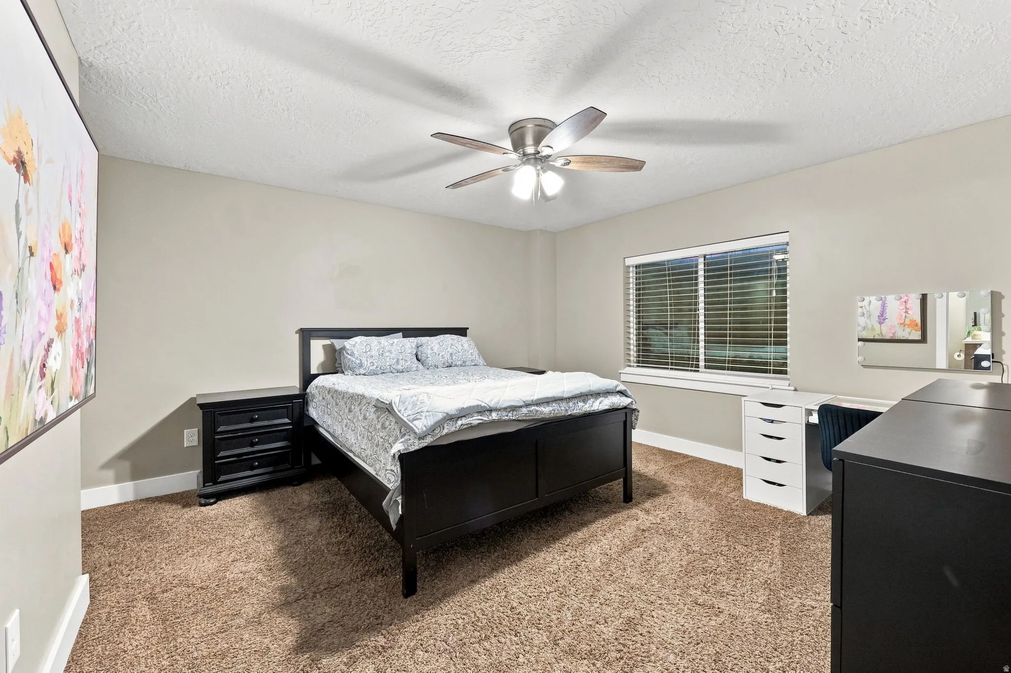 Brown carpet flooring, neutral painted walls, window with blinds, and a ceiling fan with light fixture