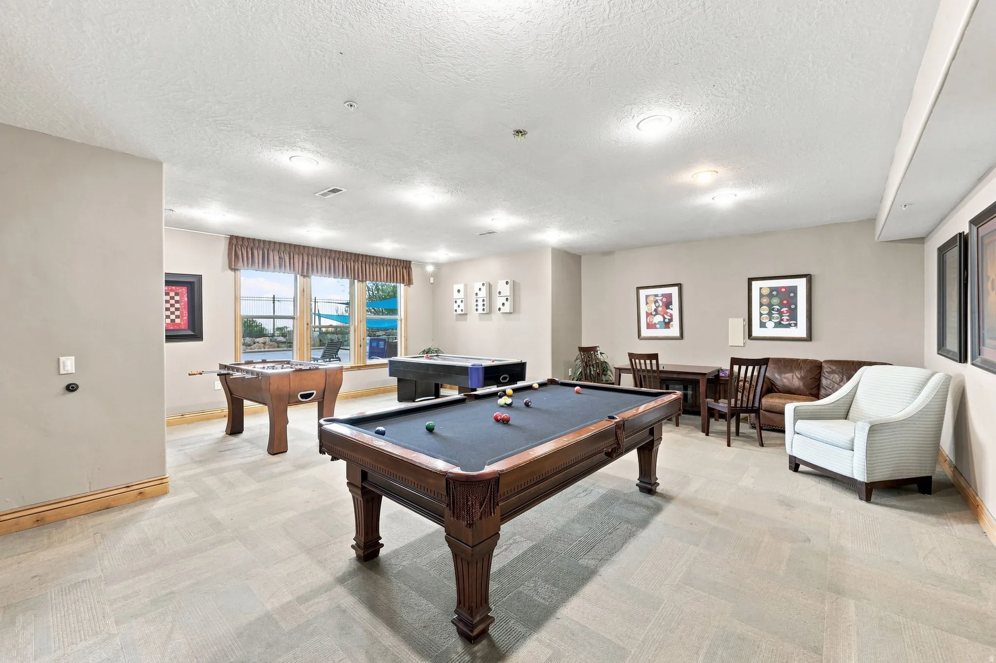 Spacious recreation room featuring recessed lighting, large windows, and light-toned flooring