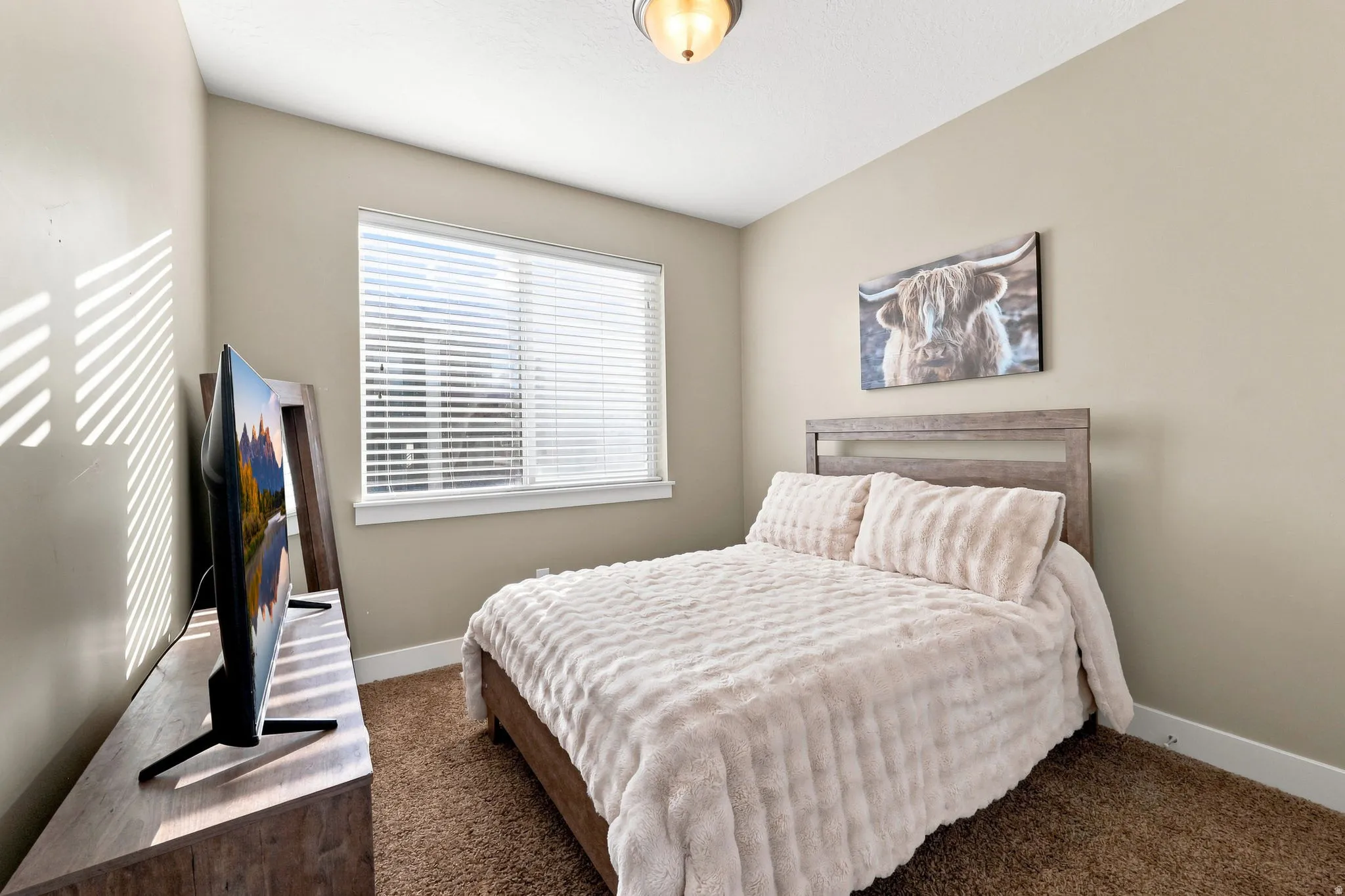 Neutral-toned walls complement a window with blinds, providing natural light