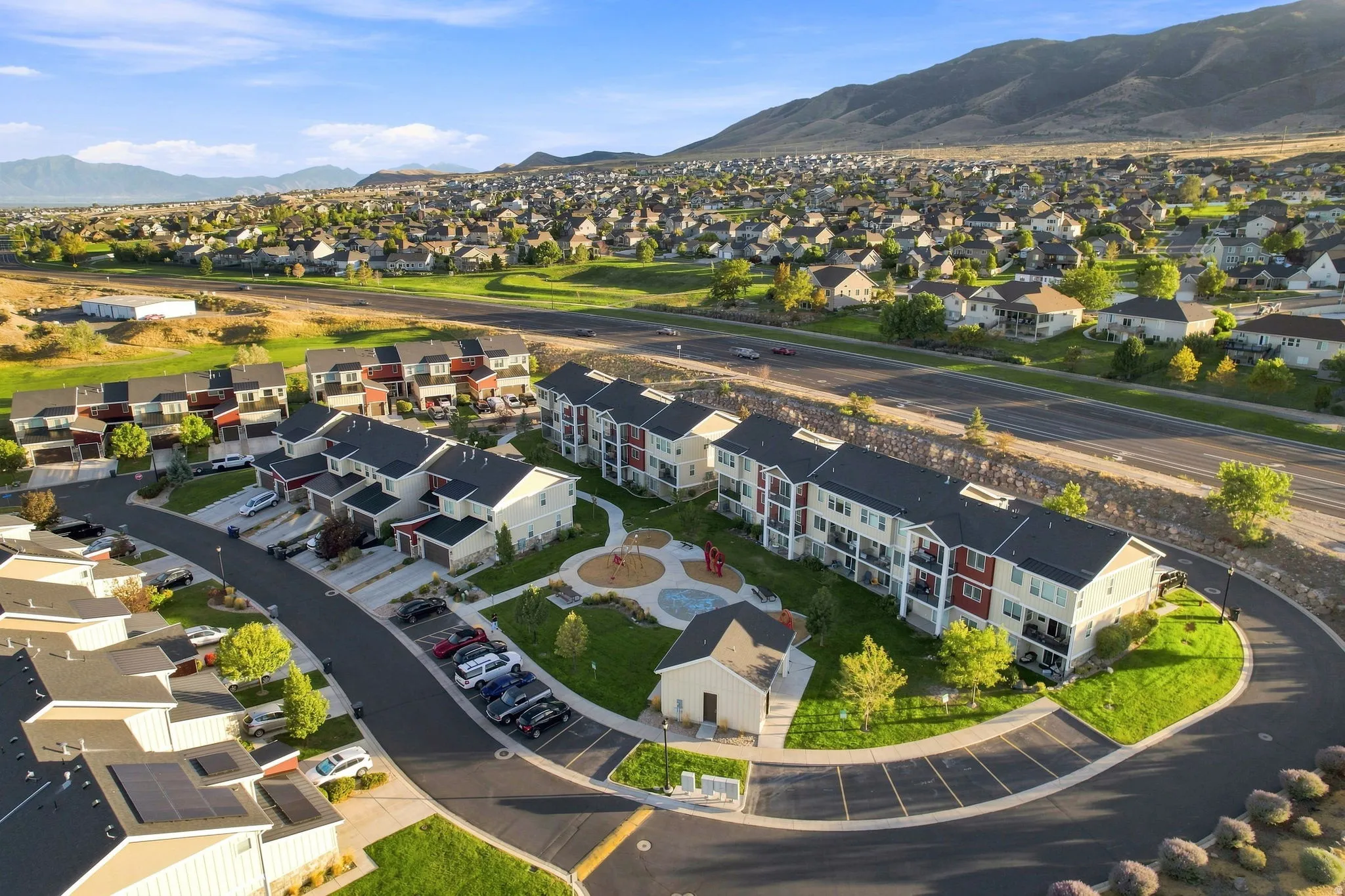 Residential development with varied architectural styles, green spaces, and mountain backdrop
