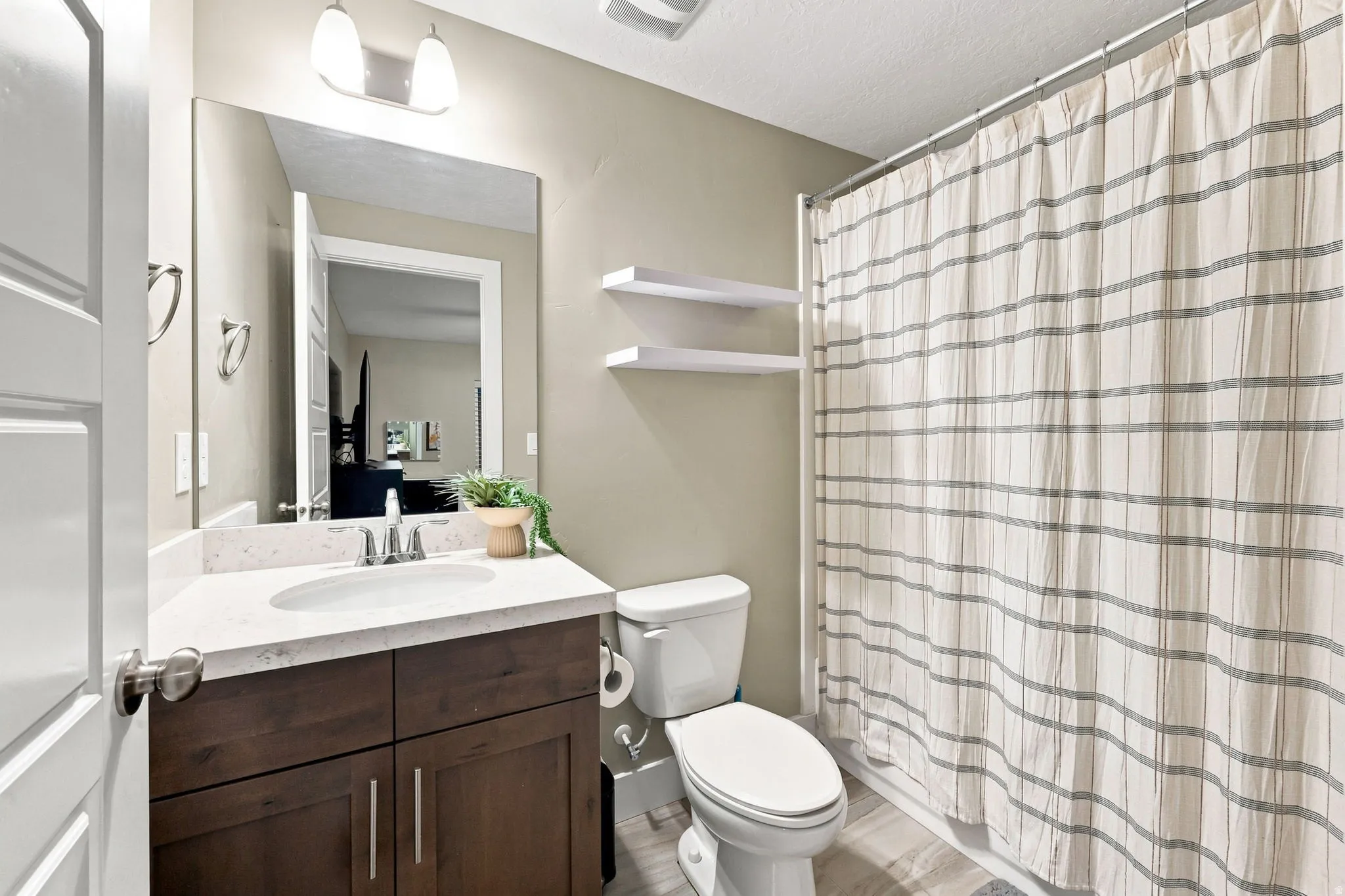 Wood-finish vanity with a white countertop and undermount sink