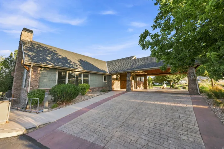 Stone and shingle exterior with a covered entryway and chimney