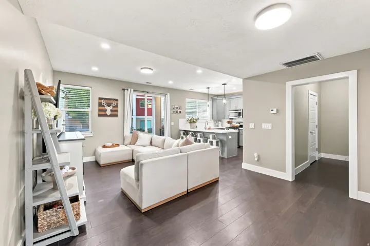Open concept living area with wood-finish flooring, recessed lighting, and a sliding glass door