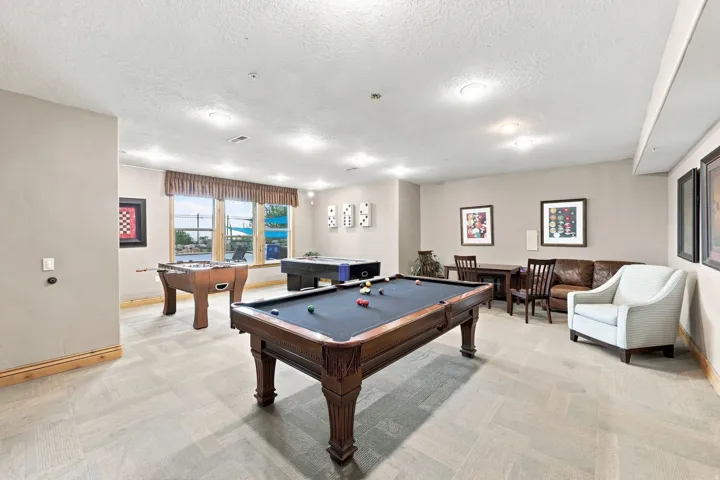 Spacious recreation room featuring recessed lighting, large windows, and light-toned flooring