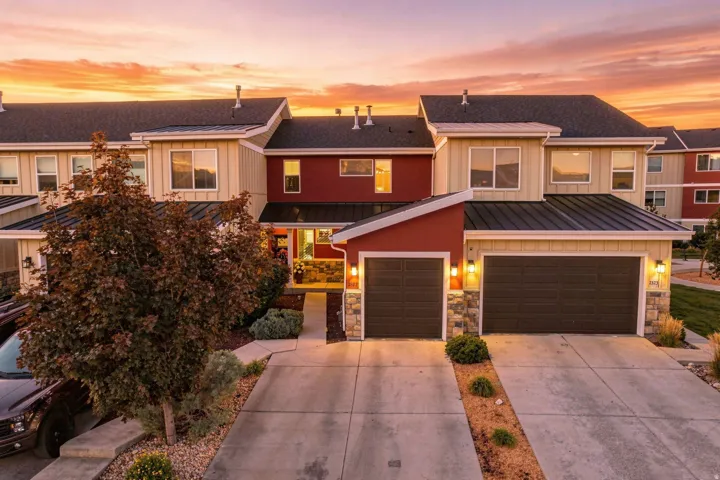 Exterior features stone accents, multiple garage bays, and a metal roof over the entry