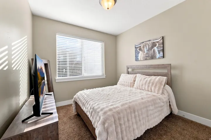 Neutral-toned walls complement a window with blinds, providing natural light