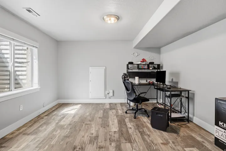 Recessed window with white trim, wood-finish flooring, white walls, and flush-mount ceiling light