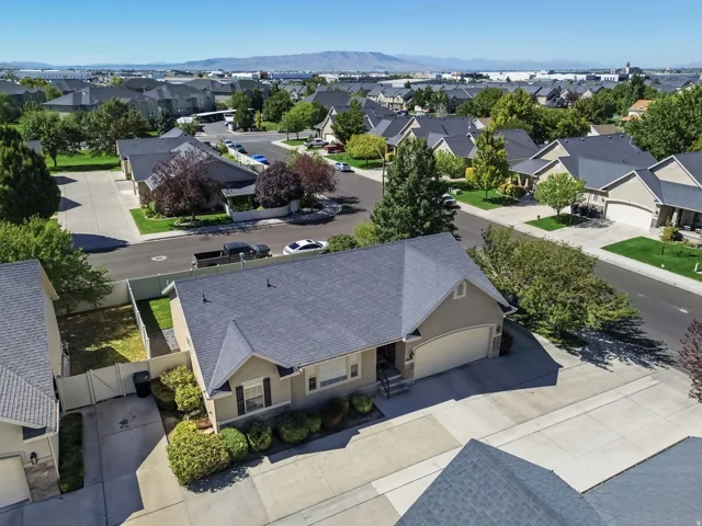 Single-story residence featuring a two-car garage, established front landscaping, paved driveway, and a fenced backyard