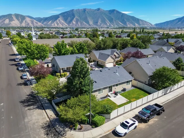 Mountain backdrop, residential street, manicured landscaping, private fencing, concrete patio