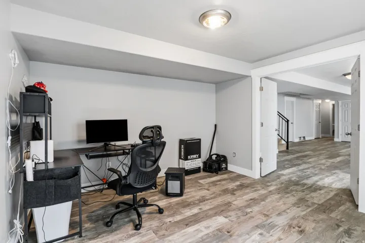 Wood-finish flooring throughout, light gray wall paint, white trim, and recessed ceiling lighting