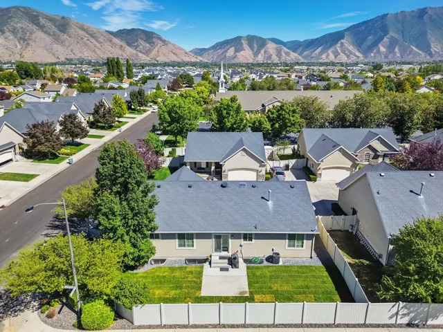 Expansive backyard with a manicured lawn, established landscaping, and privacy fencing