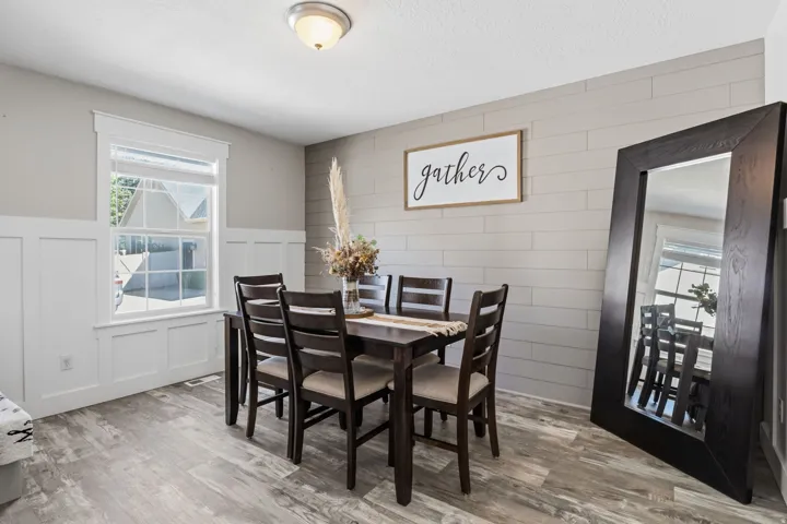 Board and batten wainscoting, a feature wall with horizontal paneling, wood-finish flooring, and a ceiling-mounted light fixture