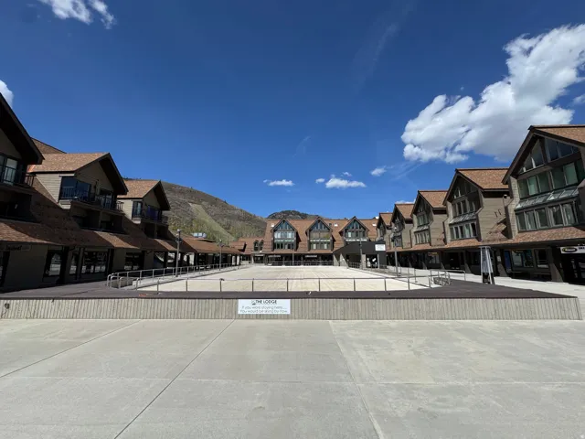 Multi-story structures with pitched roofs, balconies, and ground-level retail spaces