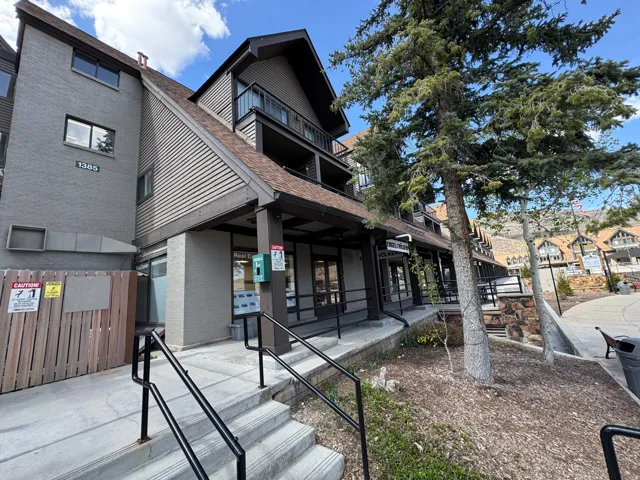 Multi-level building with textured siding and a prominent roofline