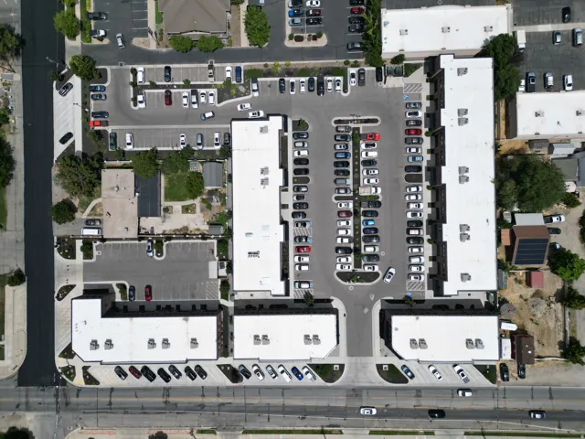Expansive multi-building property featuring multiple parking areas, asphalt paving, and mature landscaping