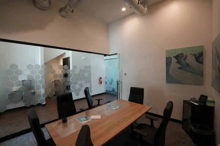 Glass wall with honeycomb pattern, high ceilings, exposed ductwork, recessed lighting, and wood-finish flooring